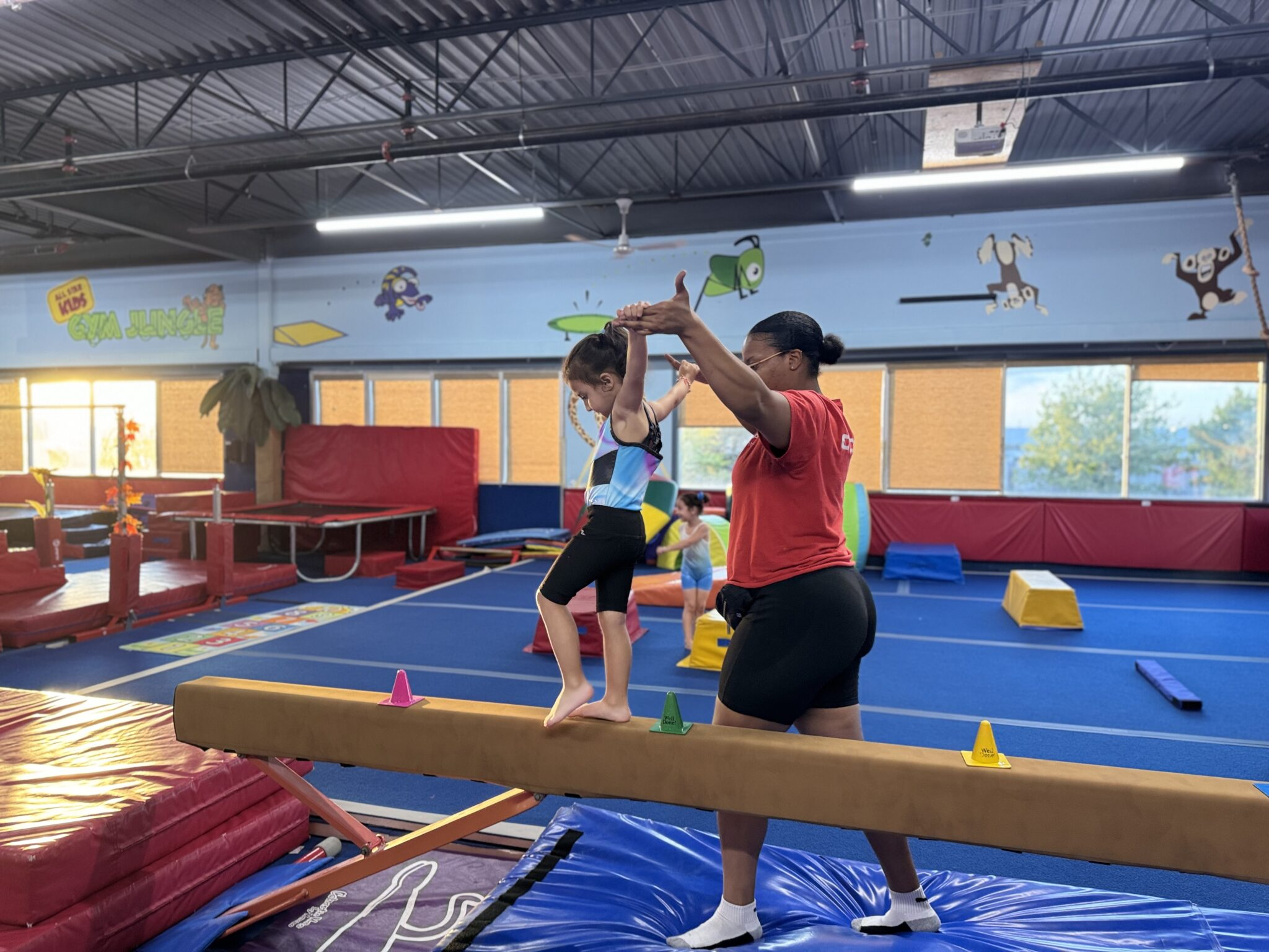 Young children in a jungle-themed gymnastics environment having fun and learning motor skills