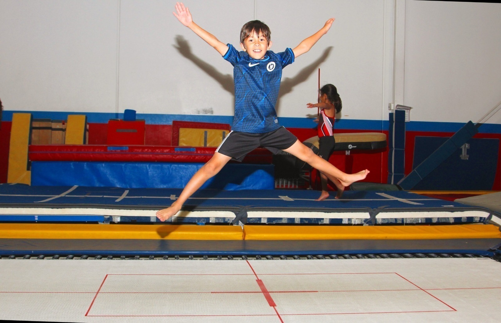 Campers engaging in active trampoline and tumbling gymnastics