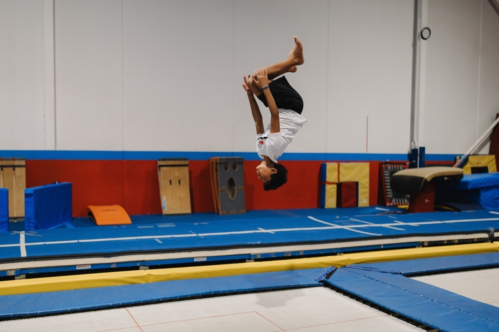 Aspiring gymnast practicing flip and tumbling skills in a safe gym environment